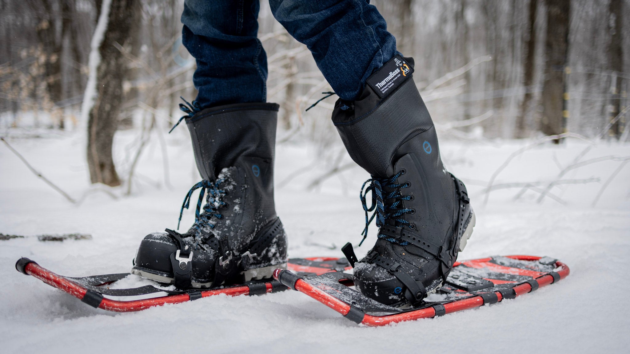 Person wearing AirBoss ThermoBoss™ boots and snowshoes in a snowy forest